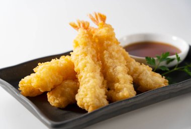 Beyaz arka plana yerleştirilmiş bir tabakta karides tempurası. Tempura bir Japon yemeğidir. Japon kızarmış karidesi.. 
