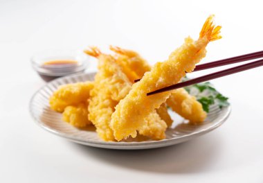 Beyaz arka plana yerleştirilmiş bir tabakta karides tempurası. Tempura bir Japon yemeğidir. Japon kızarmış karidesi.. 