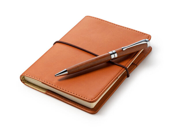 Leather notebook and pen placed against a white background. Business image.