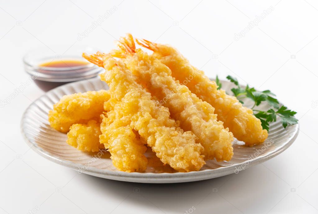 Shrimp tempura on a plate placed on a white background. Tempura is a Japanese food. It is Japanese fried shrimp. 