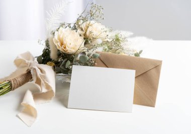 Dried flower bouquets and blank message cards placed on white tables. Wedding and celebration concept.