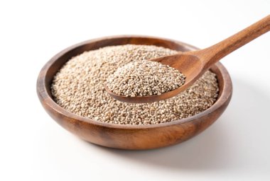 Beyaz arka planda duran ahşap bir tabakta beyaz chia tohumları ve kaşıkla kepçelendi. Yakın plan.. 