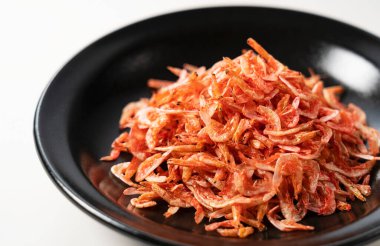 Beyaz arka planda duran tabakta kurutulmuş sakura karidesi. Japon yemeği görüntüsü. 