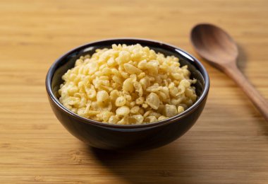 Tenkasu ve ahşap bir arka planda duran bir kasede servis edilen tahta kaşık. Japon yemeği görüntüsü.