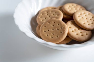 Fotokopi alanı olan beyaz bir arkaplana yerleştirilmiş bir çanakta bir sürü kurabiye. 