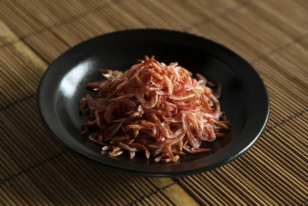 在放在竹子午餐垫子上的盘子里的干腊肠虾仁 日本食品的形象 — 图库照片