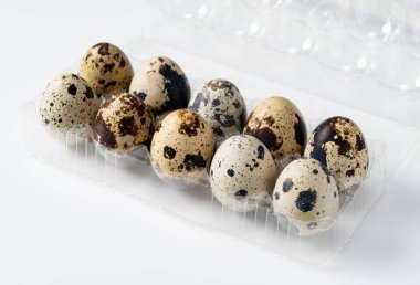 Quail eggs in a pack placed on a white background