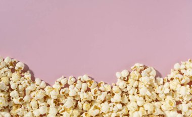 Pembe arka planda patlamış mısır ve fotokopi alanı. Doğrudan yukarıdan bakıldığında.