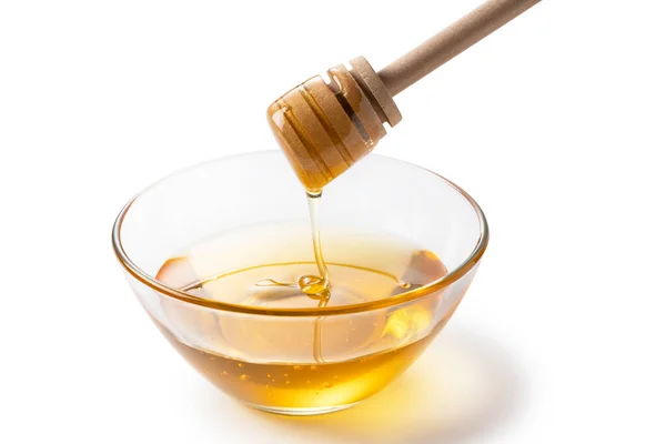 蜂蜜和蜂蜜浸渍在白色背景的玻璃碗里 蜂蜜从蜂蜜搅拌器上滴下 — 图库照片