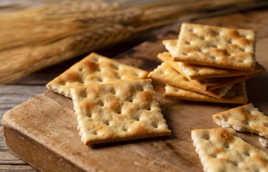 Eski ahşap arka plana yerleştirilmiş kraker. Yakın plan..