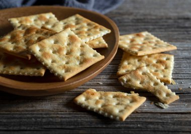 Eski ahşap arka plana yerleştirilmiş kraker. Yakın plan..