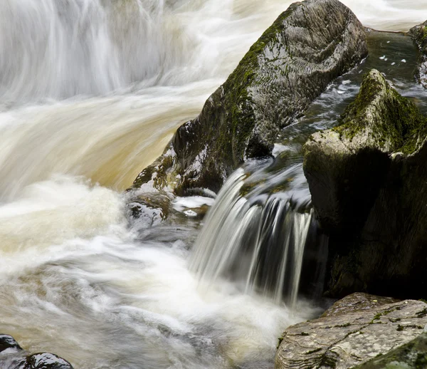 Fresh water flowing along a steep and rocky section of river — Stock Photo, Image