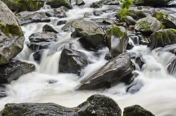 Fresh water flowing along a steep and rocky section of river — Stock Photo, Image