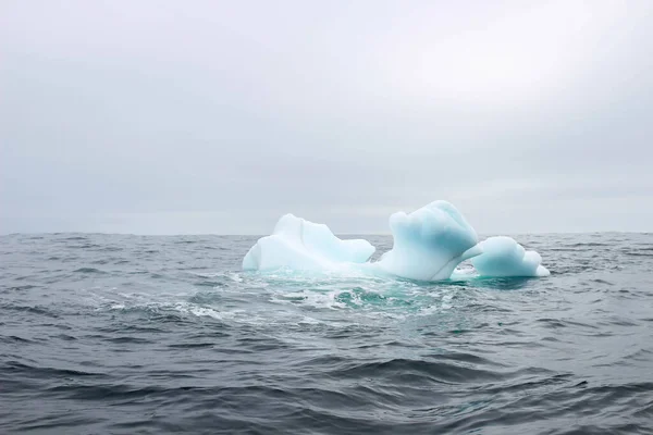 Κύμα Συντρίβεται Μικρό Παγόβουνο Που Επιπλέει Στη Θάλασσα — Φωτογραφία Αρχείου