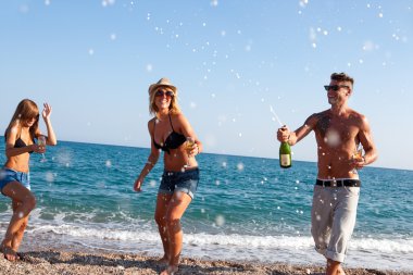 Dancing under champagne bubbles on beach. clipart