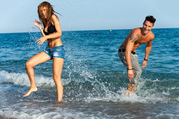 Jeune couple s'amuser avec de l'eau . — Photo