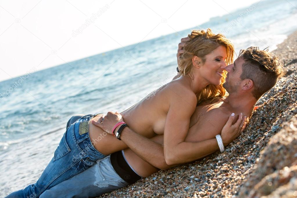 In love couple about to kiss on beach.