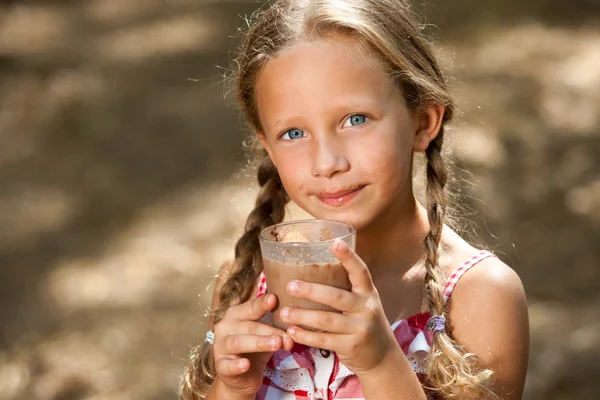 Niedliches Mädchen trinkt Milchschokolade. — Stockfoto