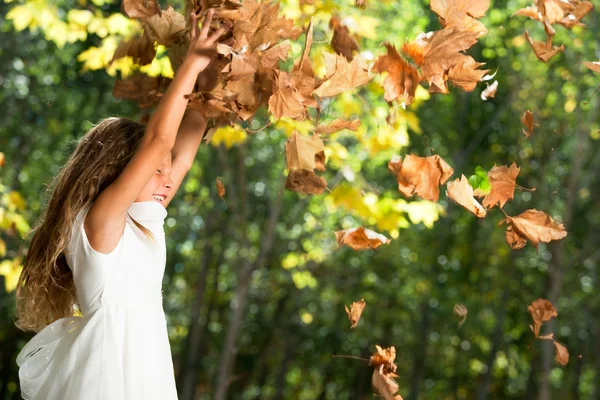 Girl playing with autumn leaves outdoors. — Stock Photo, Image
