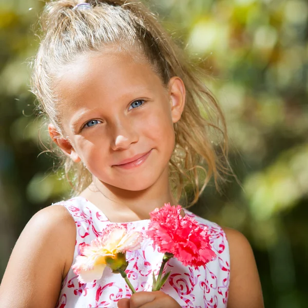 Sweet girl holding flowers outdoors. — Stock Photo, Image