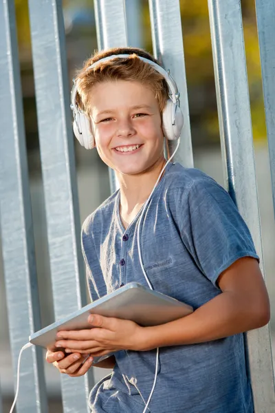 Lindo adolescente chico sosteniendo tableta al aire libre . —  Fotos de Stock