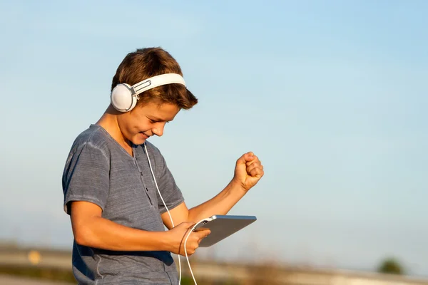 Glücklicher Junge hört Musik auf digitalem Tablet. — Stockfoto