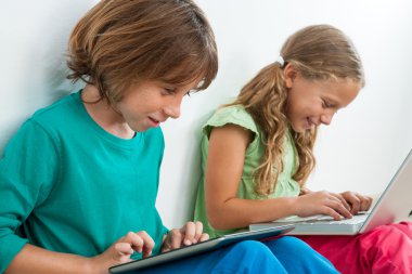 iki çocuk Tablet ve dizüstü bilgisayar üzerinde oynamak.