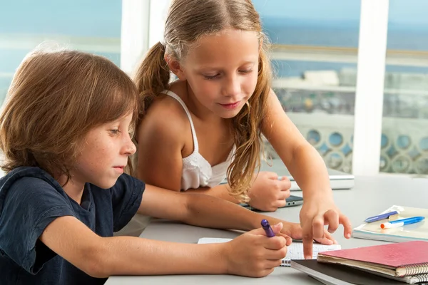 Mädchen hilft Jungen bei den Hausaufgaben. — Stockfoto