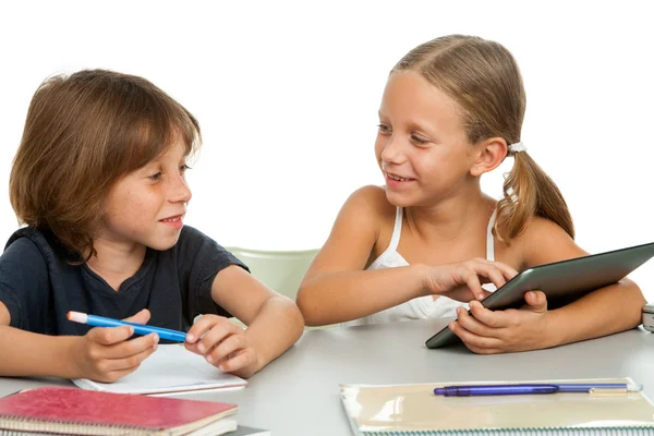 Two kids discussing homework at desk. — Stock Photo, Image