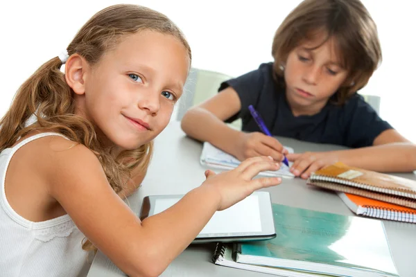 Crianças pequenas fazendo trabalhos escolares juntas na mesa . — Fotografia de Stock