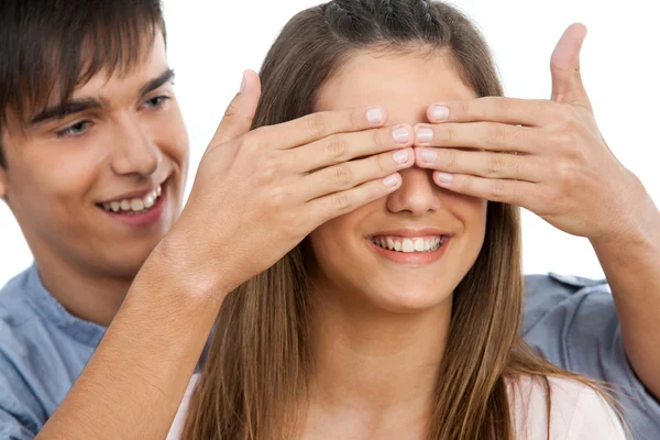 Jongen hinding meisjes ogen met handen. — Stockfoto