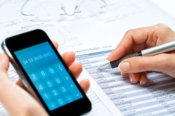 Female hands calculating budget with smart phone. — Stock Photo, Image
