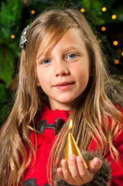Cute blond girl holding golden candle. clipart