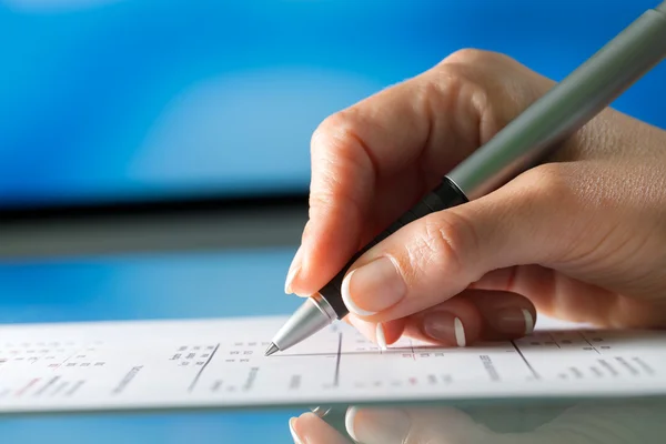 Weibliche Hand überprüft Dokument mit Stift. — Stockfoto