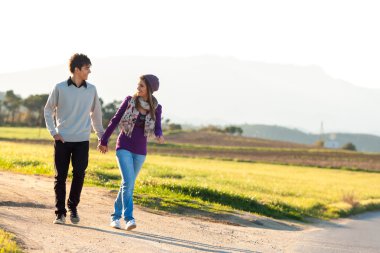 Young couple having a walk in countryside. clipart