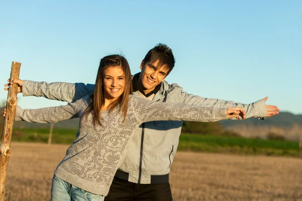 Cute couple stretching arms outdoors. — Stock Photo, Image