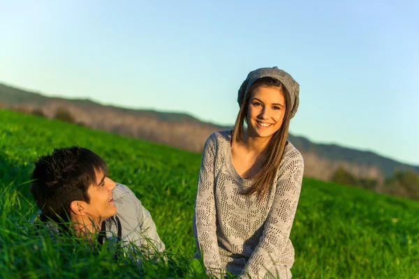 Lyckliga par avkopplande i gräsplan. — Stockfoto