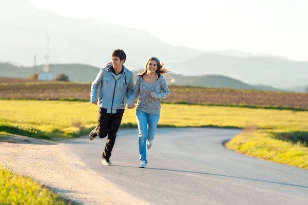 Teen couple running in countryside. — Stock Photo, Image