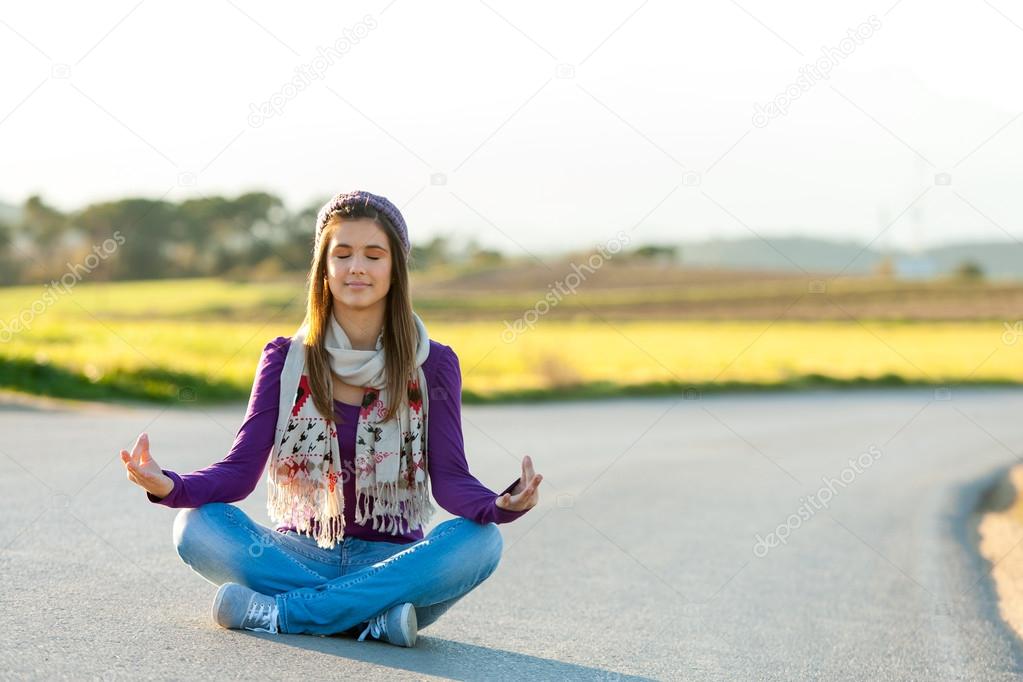 Young girl meditating outdoors.