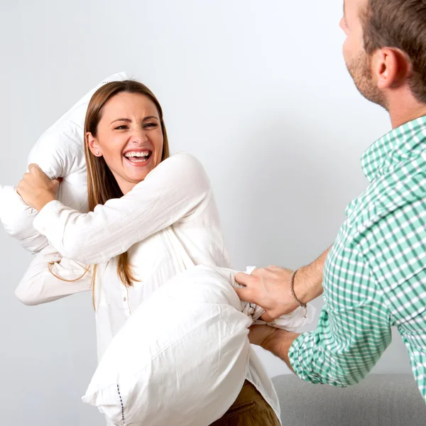 Freundin greift Freund mit Kopfkissen an. — Stockfoto