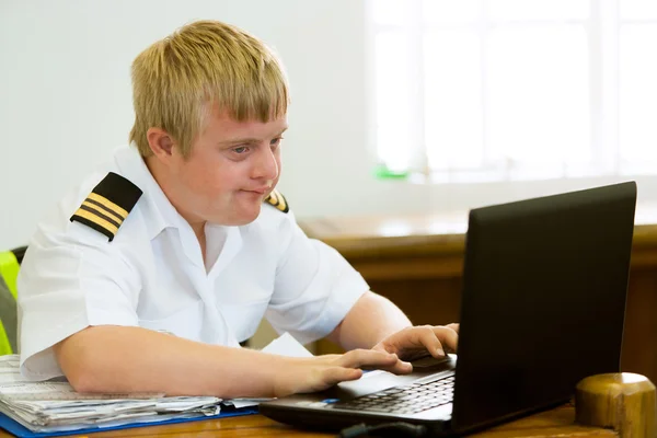 Young handicapped pilot working with laptop. — Stock Photo, Image