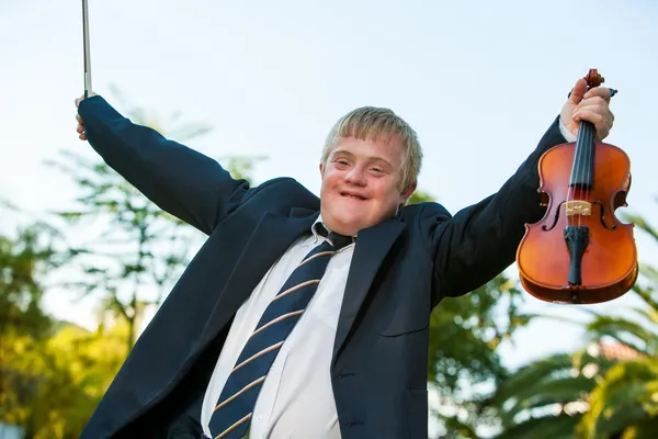 Friendly handicapped boy raising violin outdoors. — Stock Photo, Image