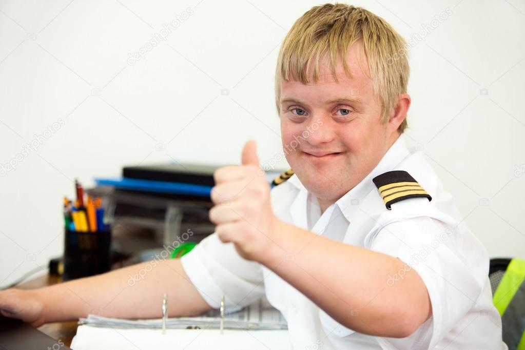 Young handicapped pilot showing thumbs up in office.