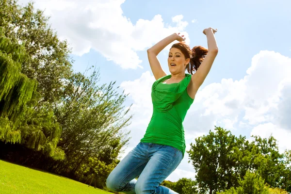 Euphoric girl jumping in park. — Stock Photo, Image