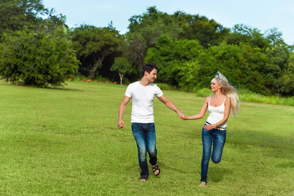 Couple courant dans un parc verdoyant . — Photo