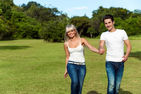 Pareja joven saltando juntos en el parque . — Foto de Stock