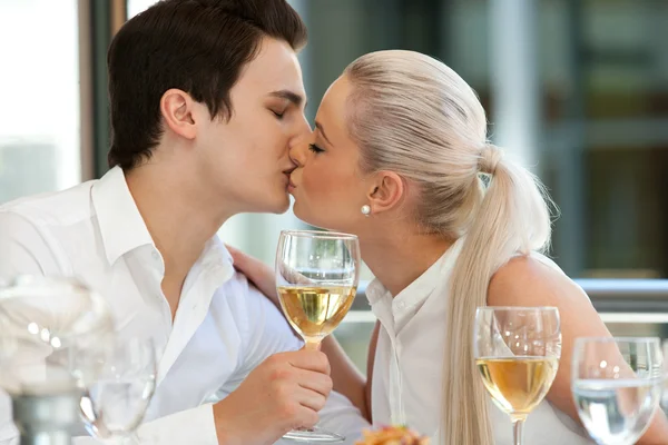 Cute couple kissing at dinner table. — Stock Photo, Image