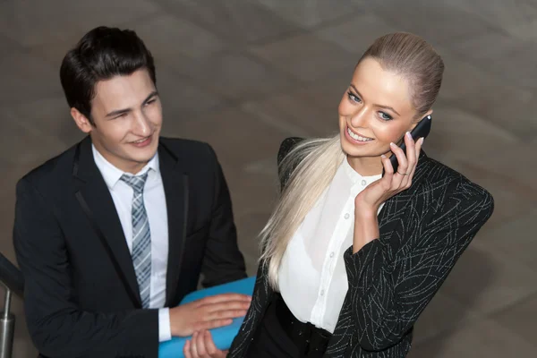 Glad affärskvinna med smart telefon och partner. — Stockfoto