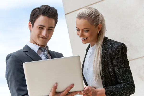 Tevreden zakenpartners herziening van werk op laptop. — Stockfoto
