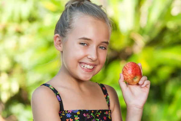 Nettes Mädchen mit rotem Apfel im Freien. — Stockfoto